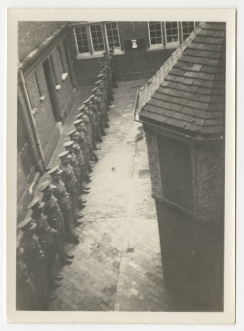 Men in uniform lined up in a courtyard