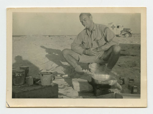 Arthur Howe, Jr. preparing food in the desert. Recto