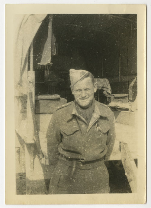 Charles "Charlie" Snead standing behind a vehicle. Recto