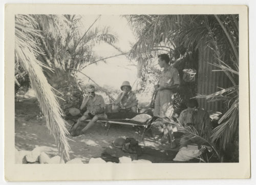 Four men at an oasis in the desert. Recto