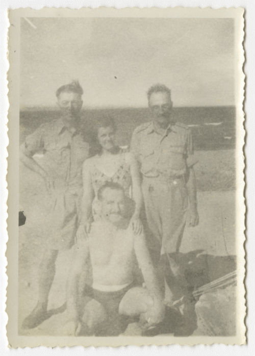 Three men and a woman on a beach